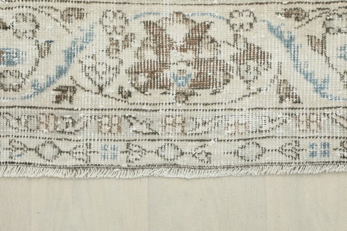 Close-up of the rug's border pattern and fringe, showing the cotton foundation.