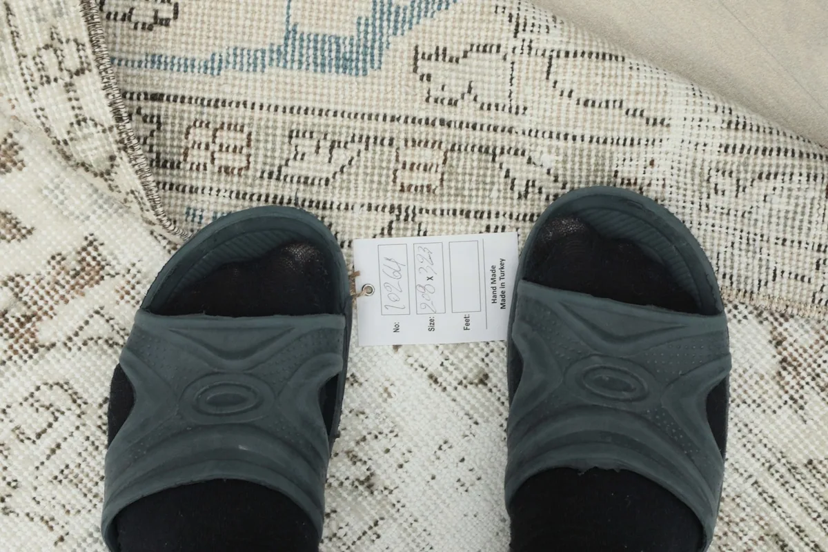Feet on the rug to show scale and texture, with a size label visible.
