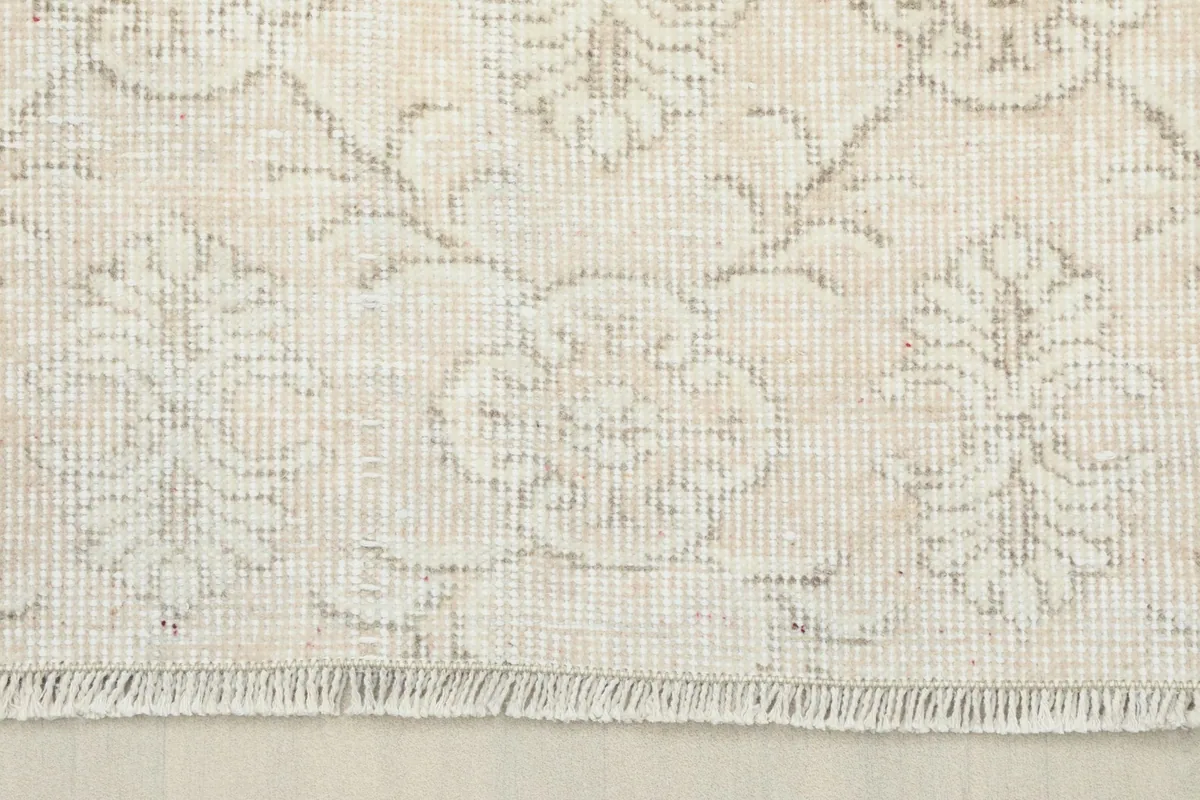 Detail of the rug's border and fringe, showing the low pile and intricate knotting