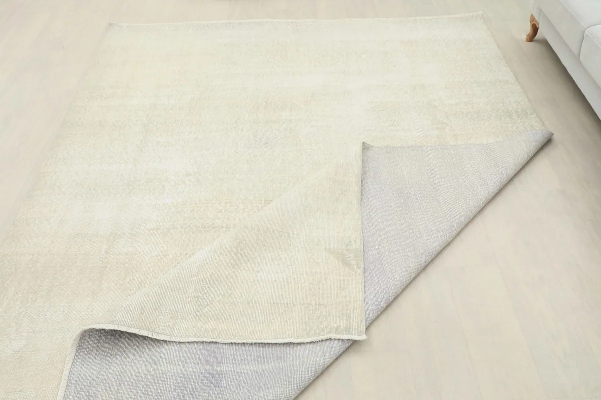 Partial view of the rug's backside, showing the hand-knotted cotton foundation.
