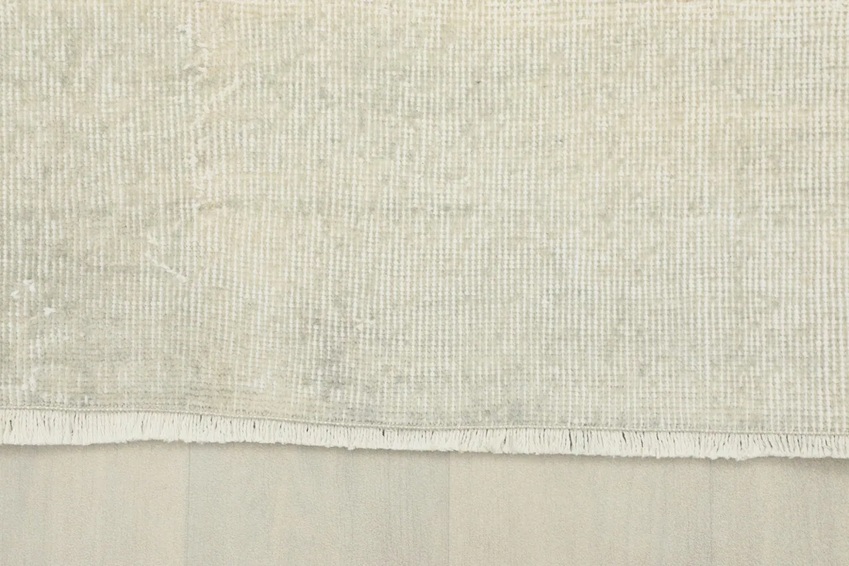 View of the rug's edge, showing the short, natural fringes and the finished border.