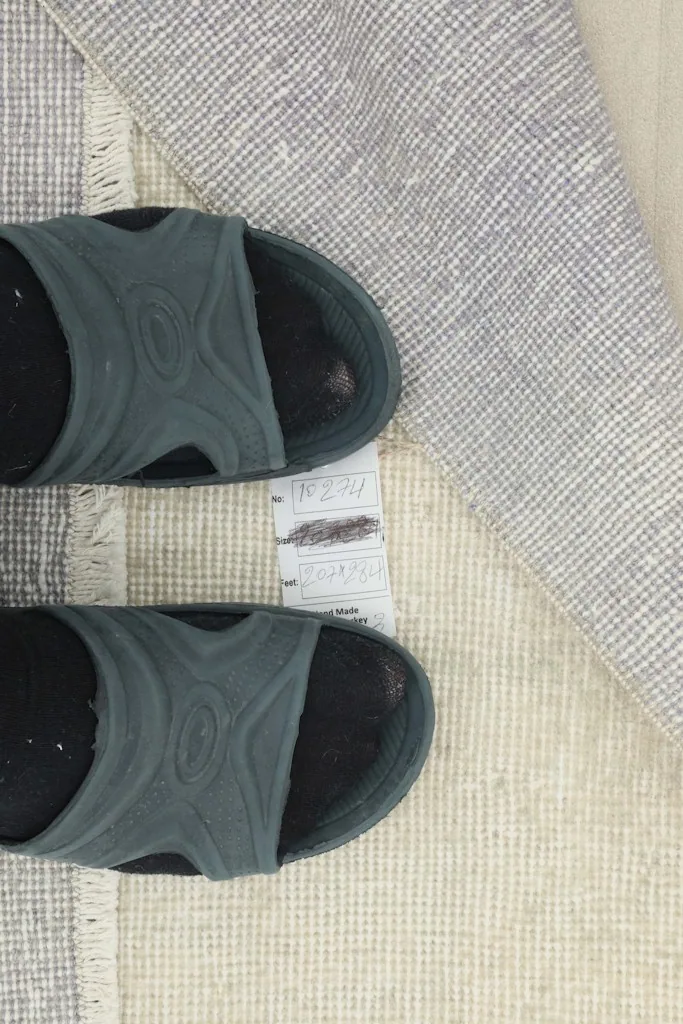 Overhead view showing the rug's thickness and the detail of the foundation next to footwear for scale.