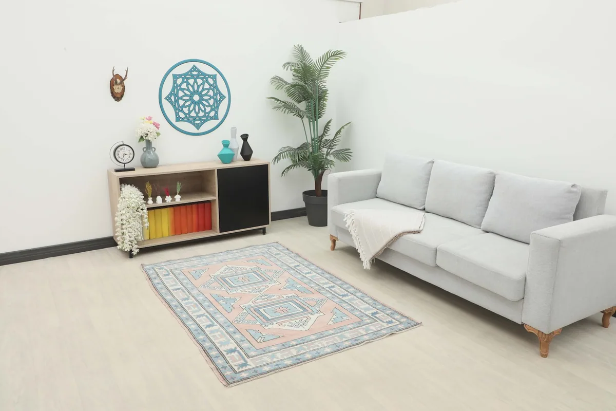 Vintage Anatolian rug in a living room setting with a light gray sofa and modern shelving.
