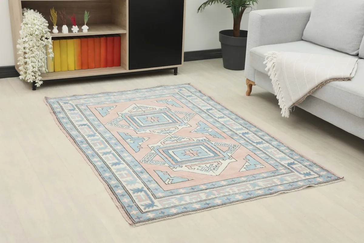 Angle view of the rose and blue geometric rug placed in a contemporary living space.