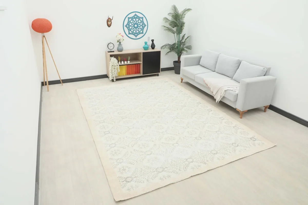 Ivory and gray vintage Anatolian rug displayed in a bright living room setting with a light gray sofa.