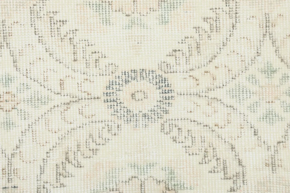 Macro detail of a specific motif, revealing the individual knots and subtle color variations in gray and blue.