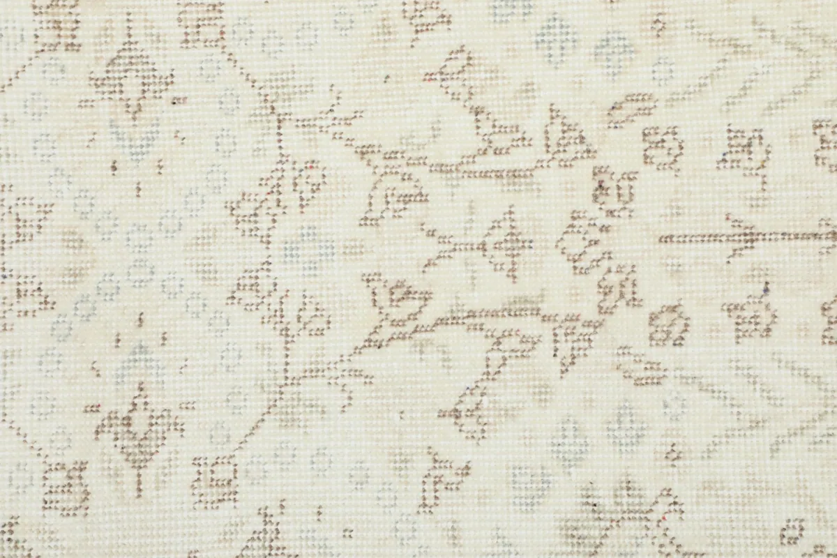 Close-up on the intricate floral and geometric patterns, revealing subtle blue and tan threads
