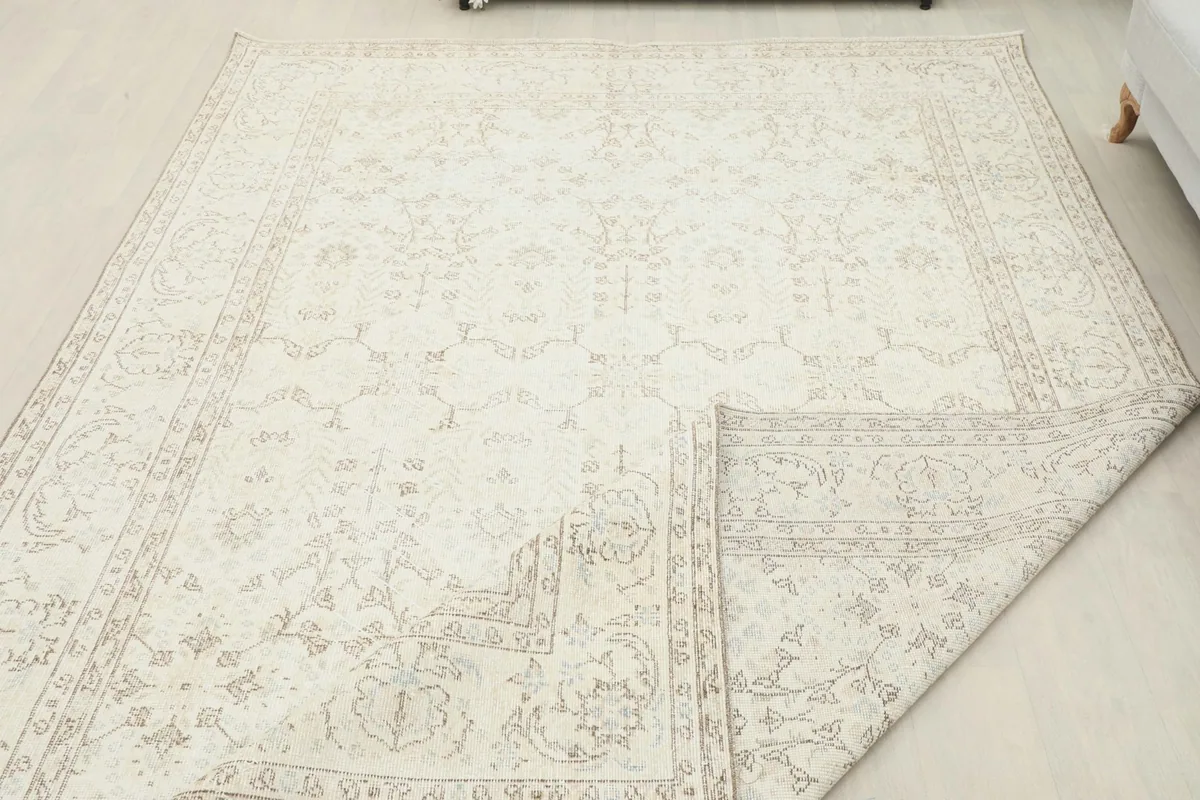 Partial view of the rug's reverse side and hand-knotted cotton foundation, with a corner folded over
