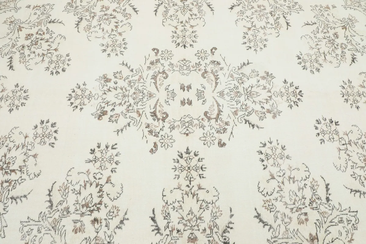 Close-up of the central medallion and surrounding floral patterns on the ivory rug