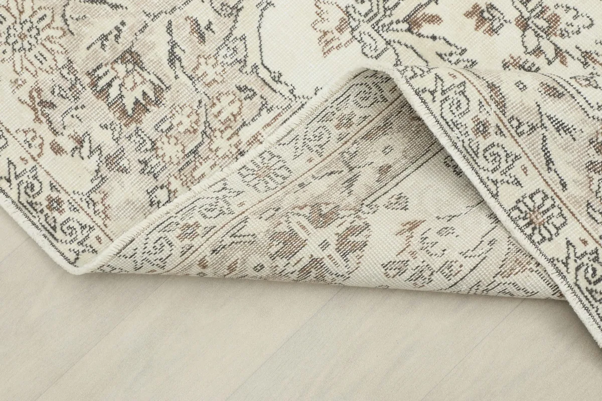 Folded corner of the rug, revealing the thickness of the wool pile and cotton foundation