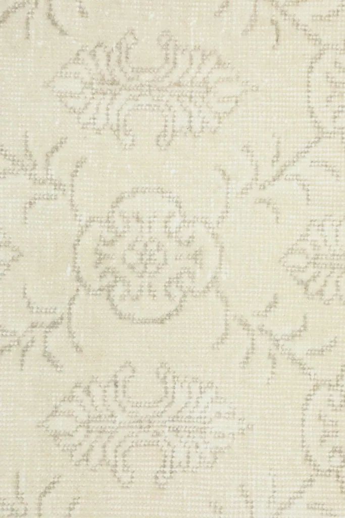 Close-up detail of the hand-knotted wool pile and the intricate gray floral geometric motifs.