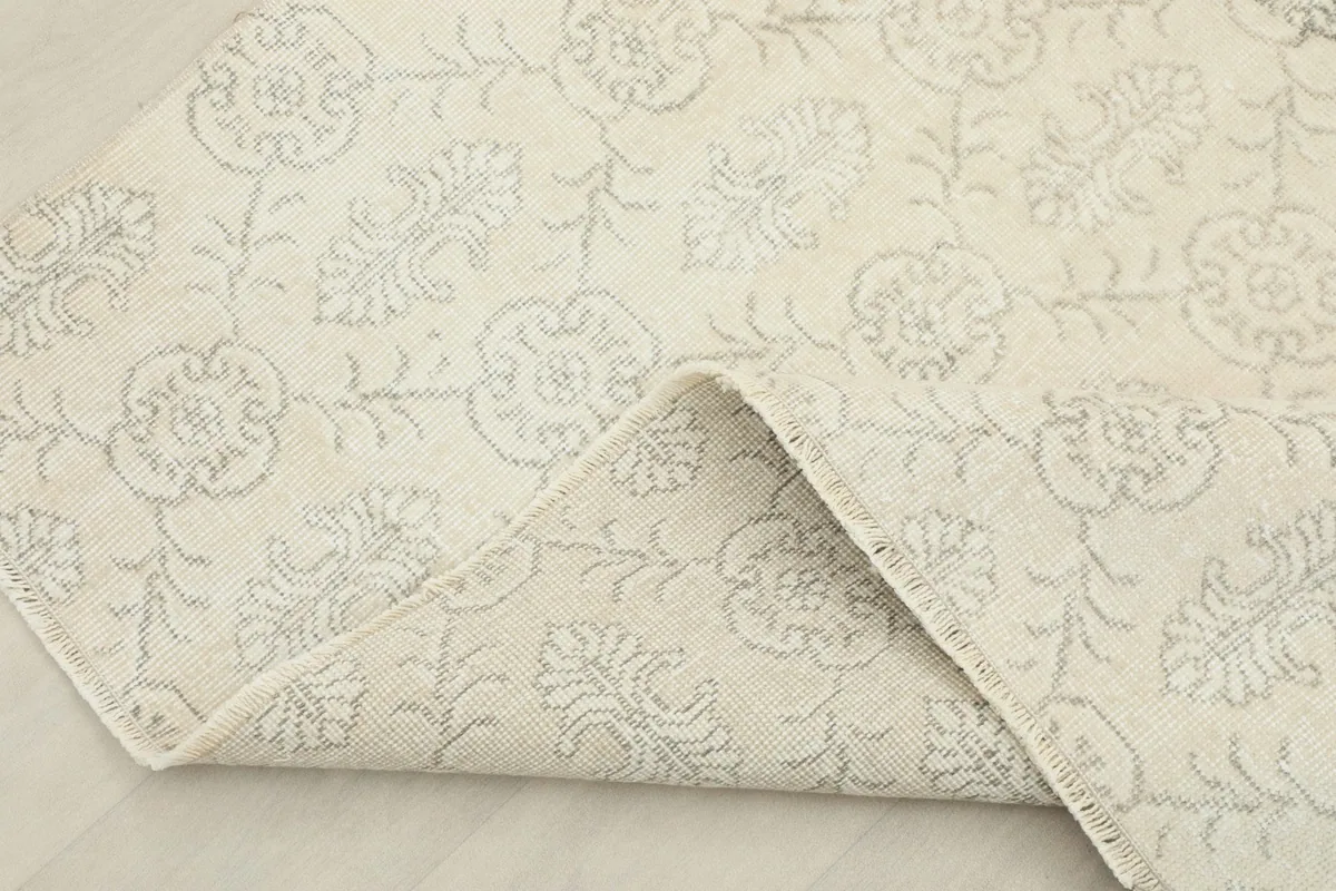 Folded corner of the rug, showing the wool pile texture and the cotton foundation beneath.