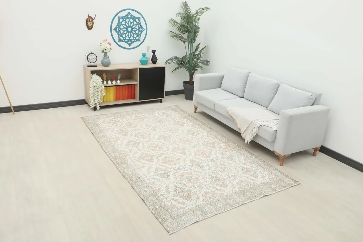 Vintage Anatolian rug displayed in a living room setting with a light gray sofa