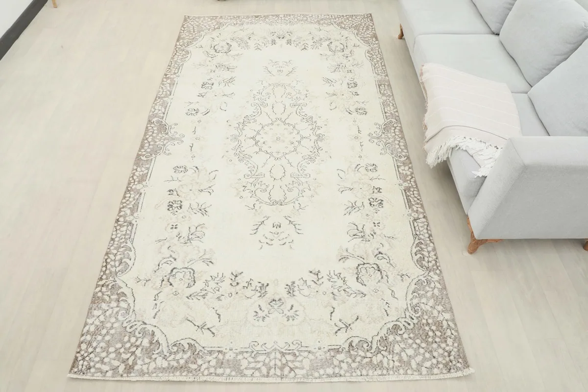 Overhead view of the large cream and beige area rug in a room, offering a full perspective of its placement