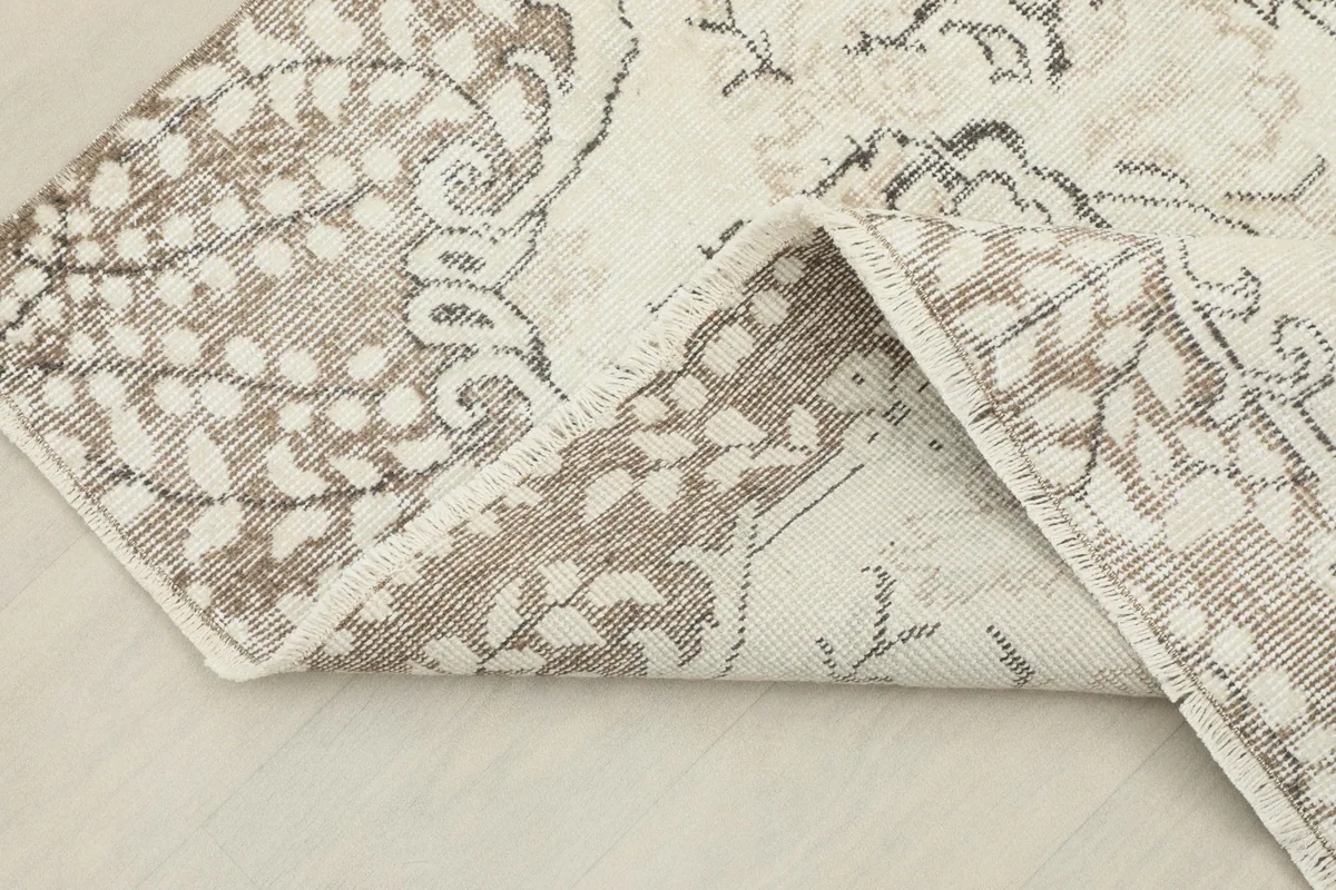 Folded corner of the rug, revealing the wool pile and cotton foundation construction