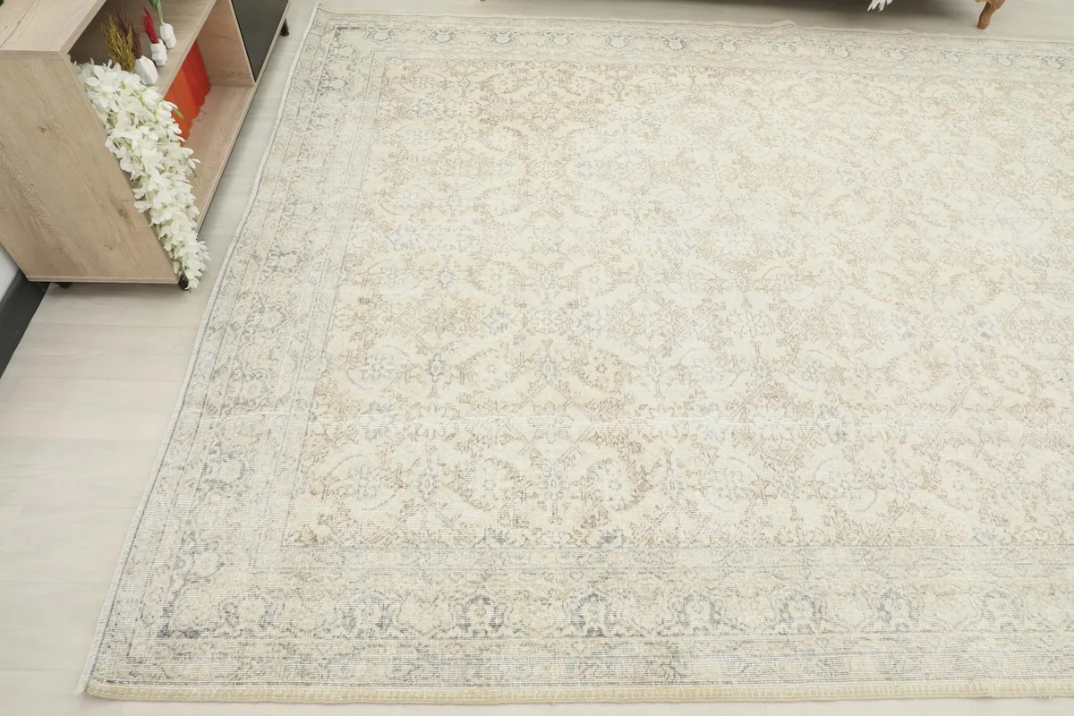 Angled shot of the rug's border and field, showing the subtle color variations and wear.