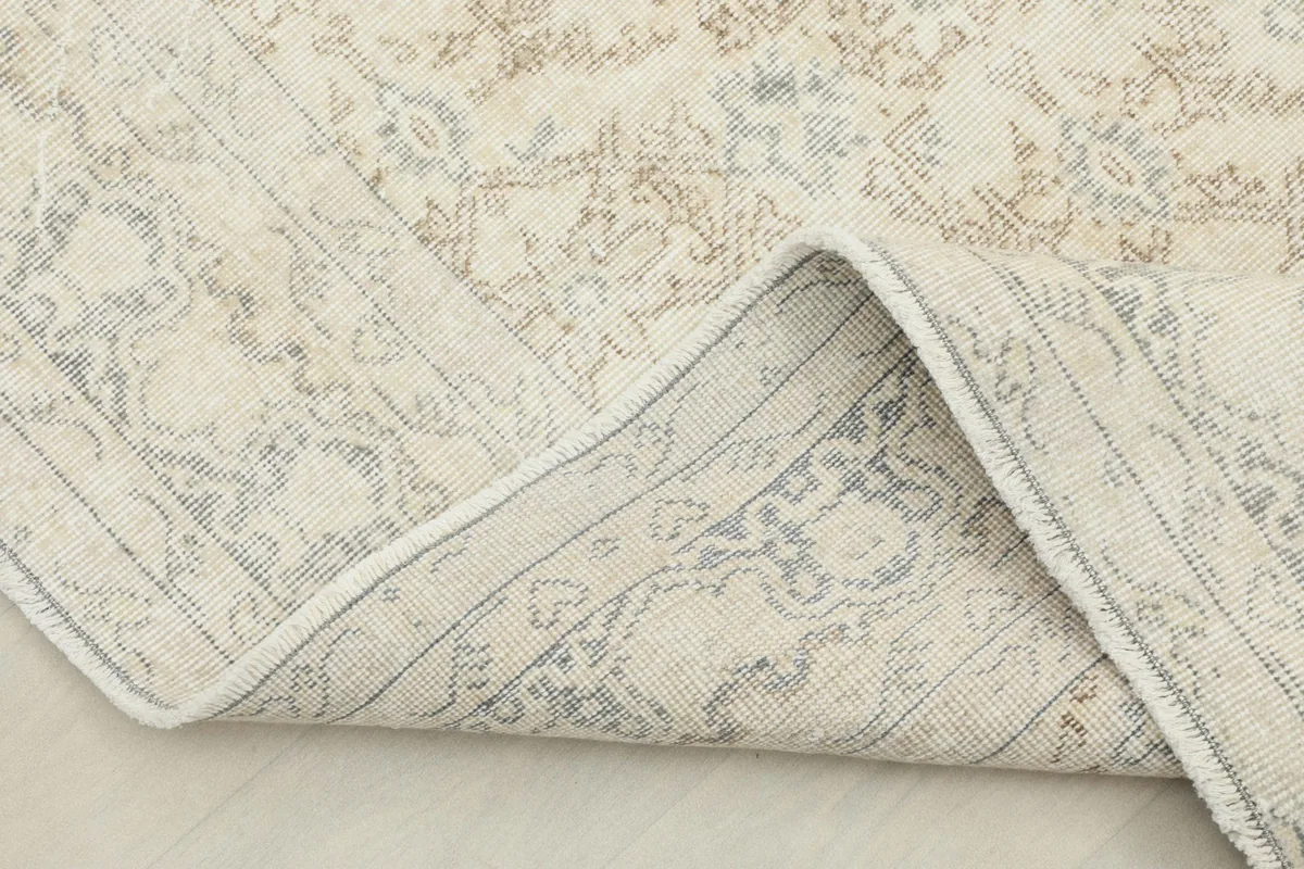 View of the rug folded back to show the cotton foundation and the reverse side.