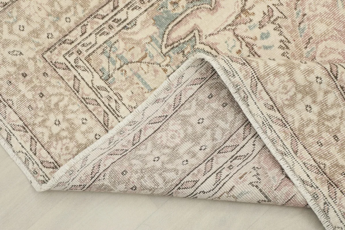 Folded corner of the rug revealing the hand-knotted wool pile on cotton foundation