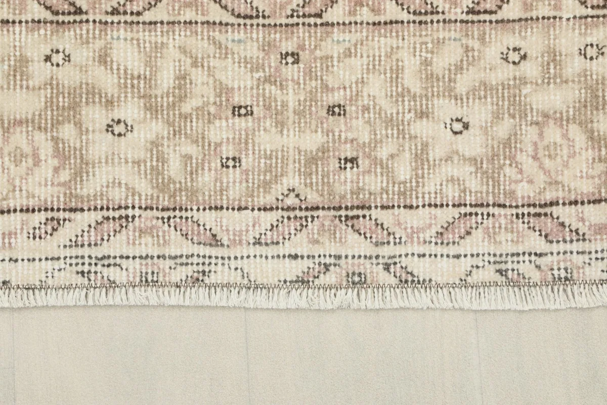 Close-up of the short, natural fringe and border design of the rug