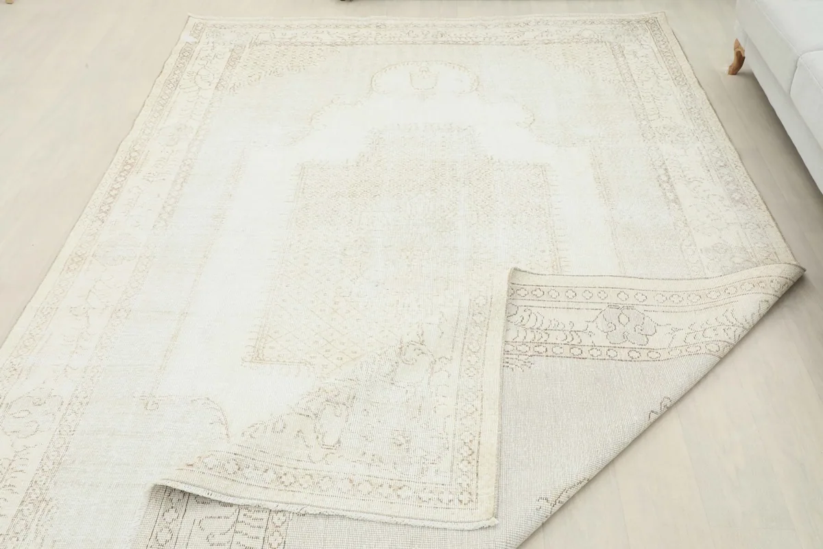 View of the rug with a corner folded, displaying the reverse side and overall field