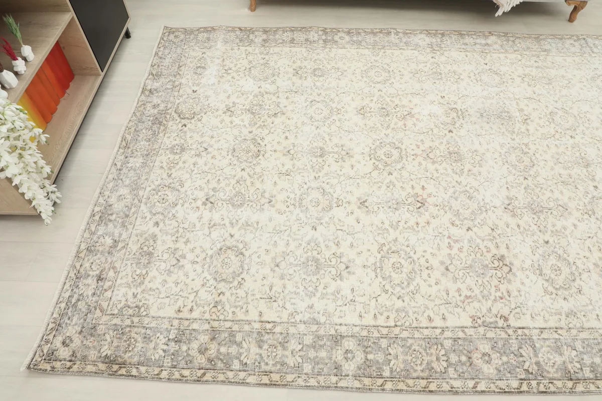 Overhead angled shot of the vintage wool rug, displaying its full pattern and distressed texture.