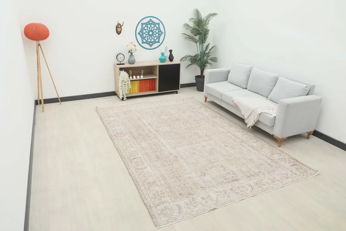 Vintage Anatolian rug displayed in a living room setting with a light-colored sofa