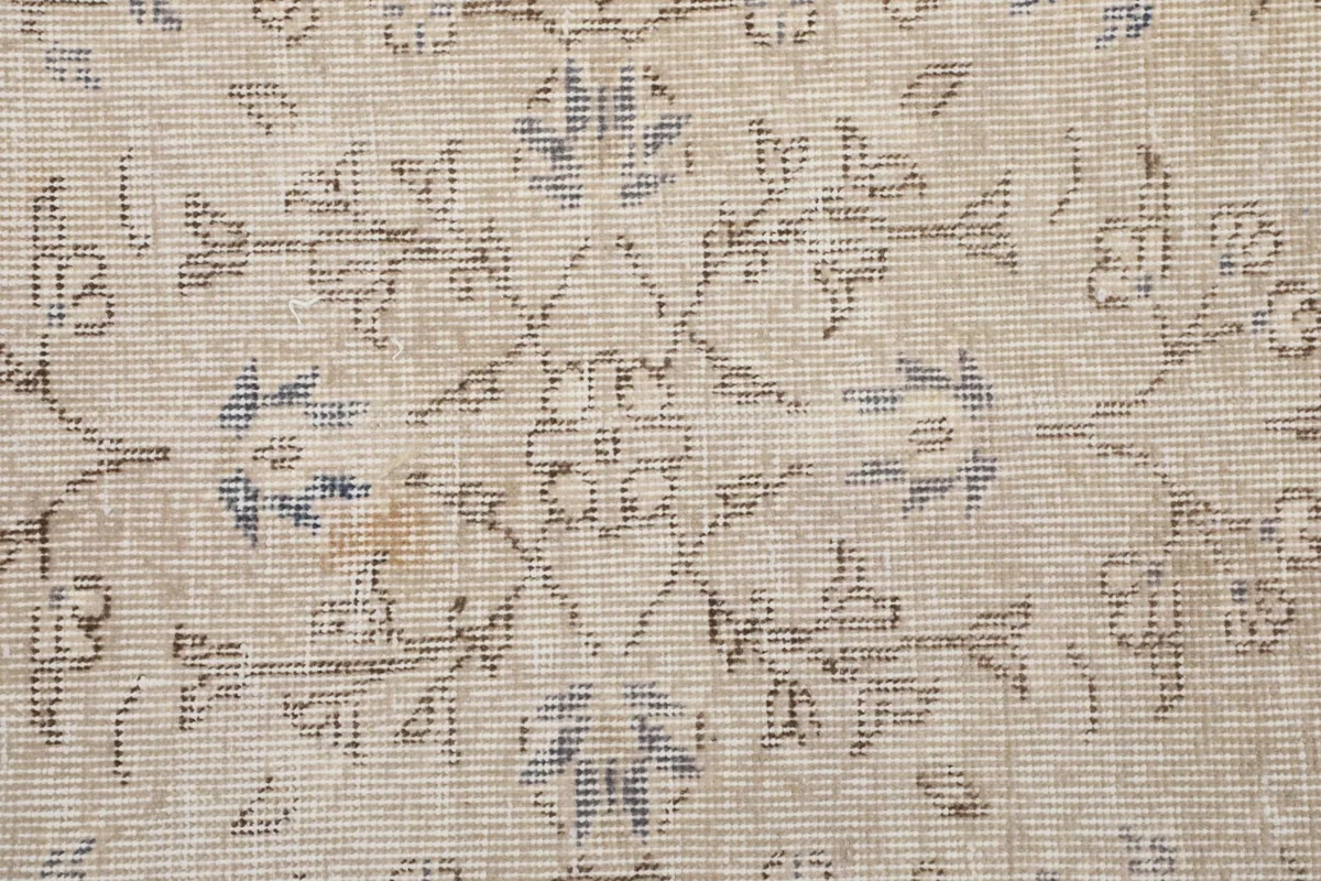 Detailed view of the wool pile and intricate patterns, including hints of blue