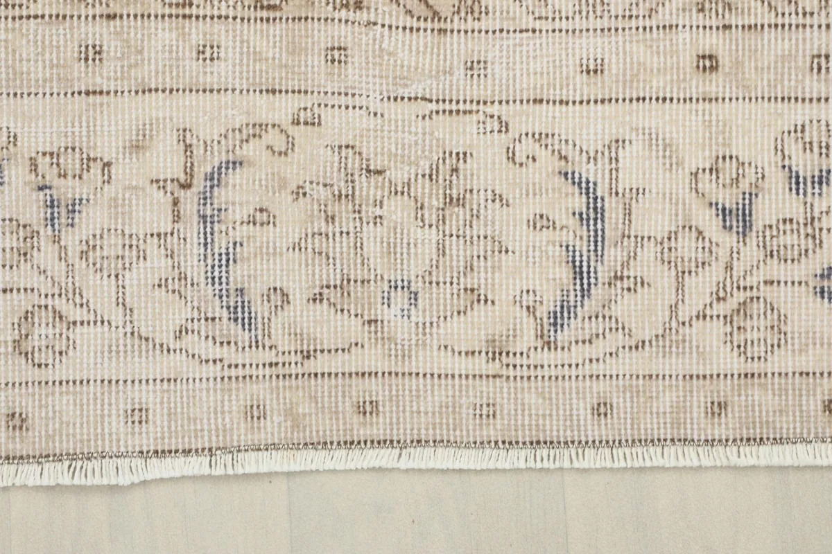 Close-up of the rug's border, revealing the detailed floral and vine design