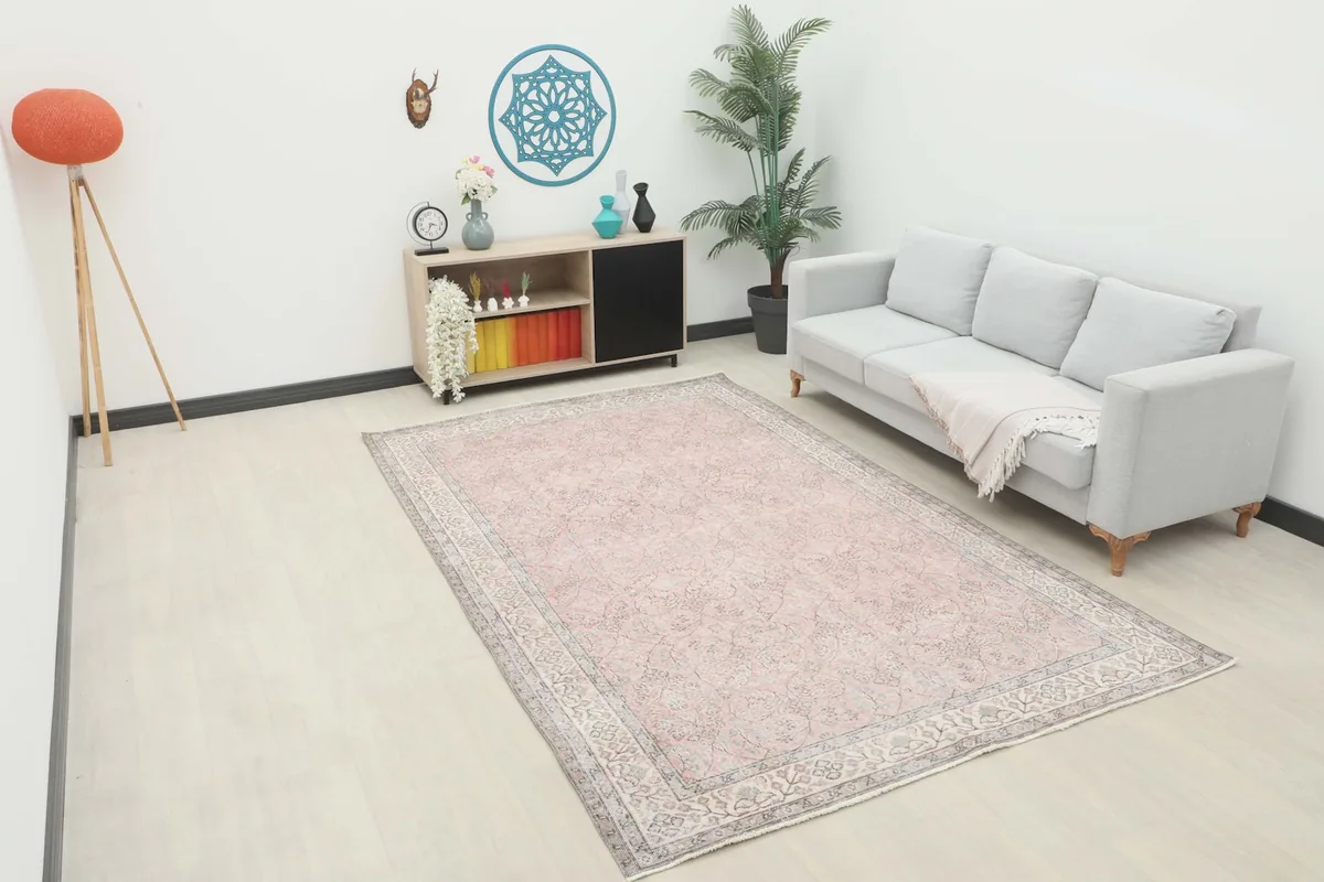 Vintage rose and gray area rug displayed in a bright living room setting with a light gray sofa.