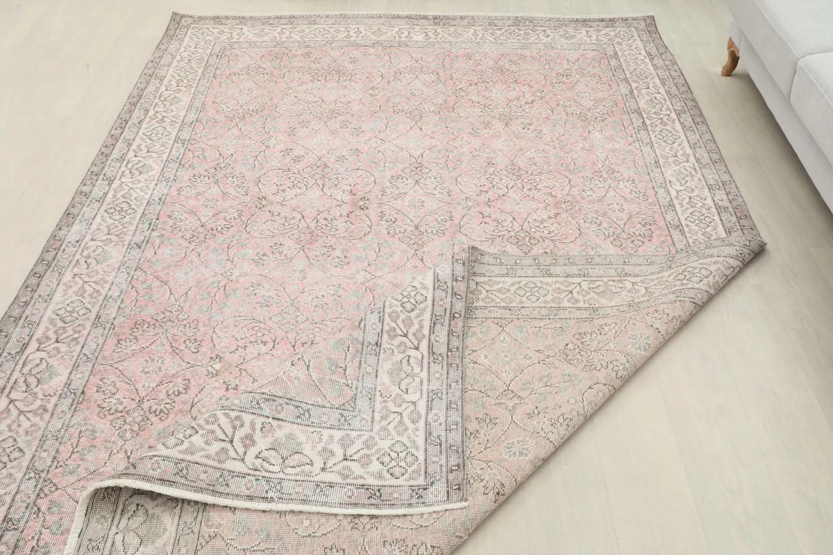 Folded corner of the rug, showing the wool pile on the front and the cotton foundation on the reverse.