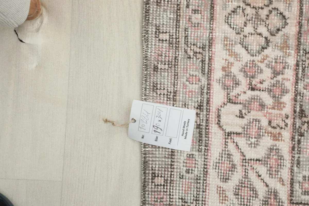 A close-up of the rug's border with a product tag, showing details of the weave and colors.
