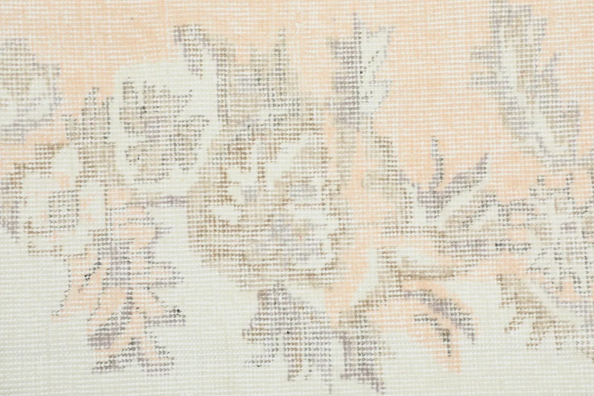 Close-up of the hand-knotted wool pile, showing the texture and color variations in orange and cream.