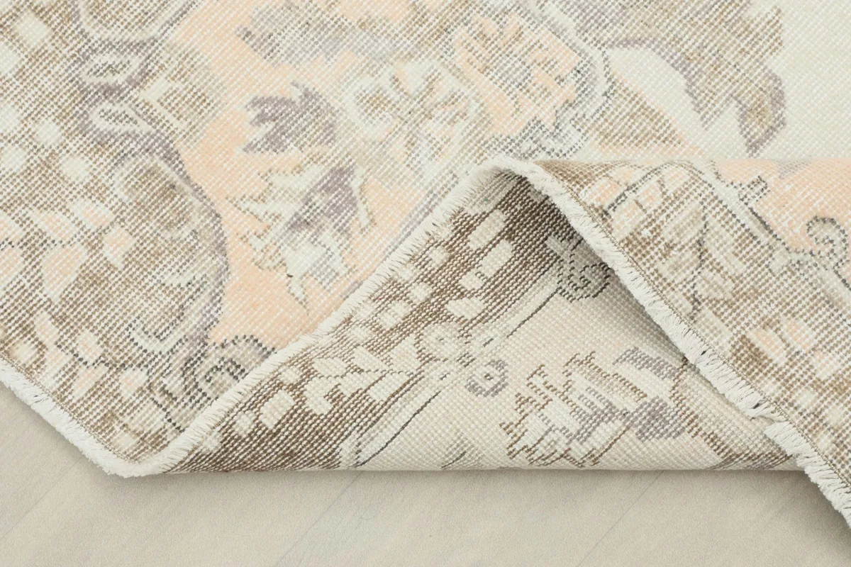 Folded corner revealing the cotton foundation and the reverse side of the hand-knotted vintage rug.