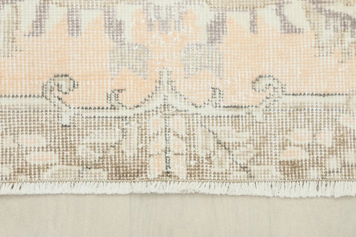 Detail of the rug's fringe and a section of the border, showcasing the hand-knotted construction.
