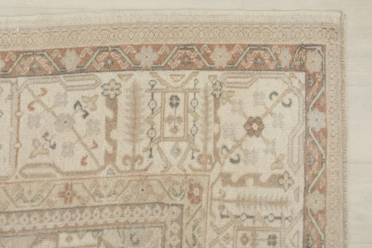 Close-up of a corner showing the geometric border pattern in rust and beige.