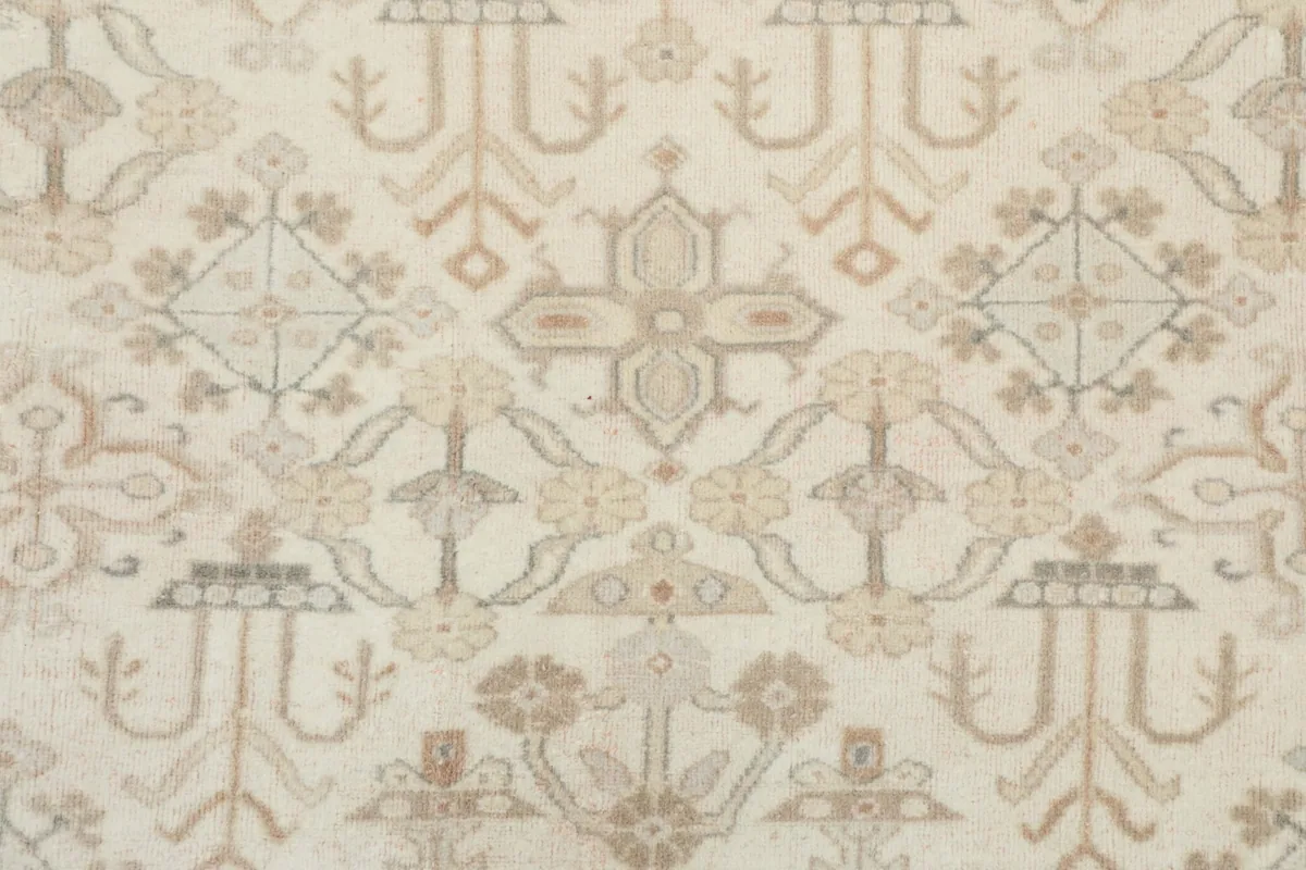 Close-up of the intricate geometric and subtle floral motifs within the rug's field.