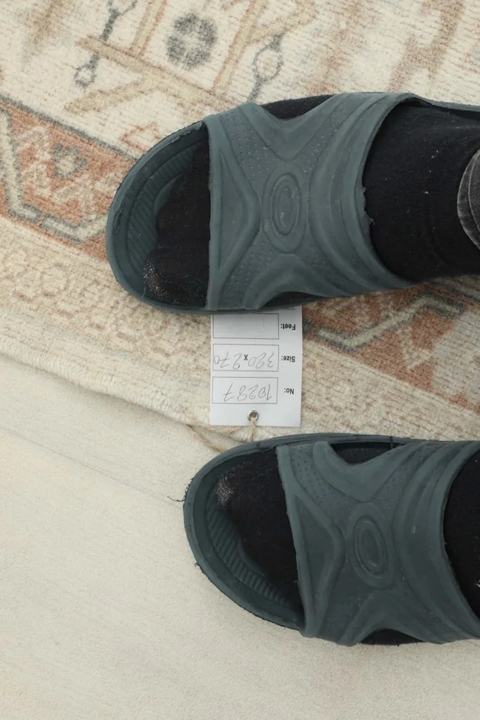 Close-up of the low wool pile and the hand-knotted texture, with size tag visible.