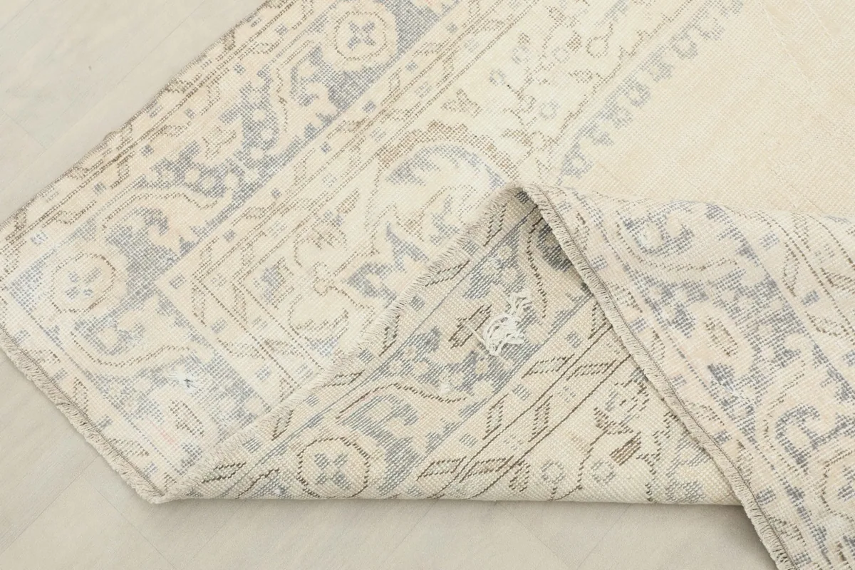 Rug corner folded back to reveal the hand-knotted wool pile and cotton foundation
