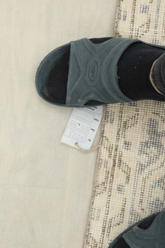 Overhead view showing a foot next to the rug to indicate scale and the low pile texture