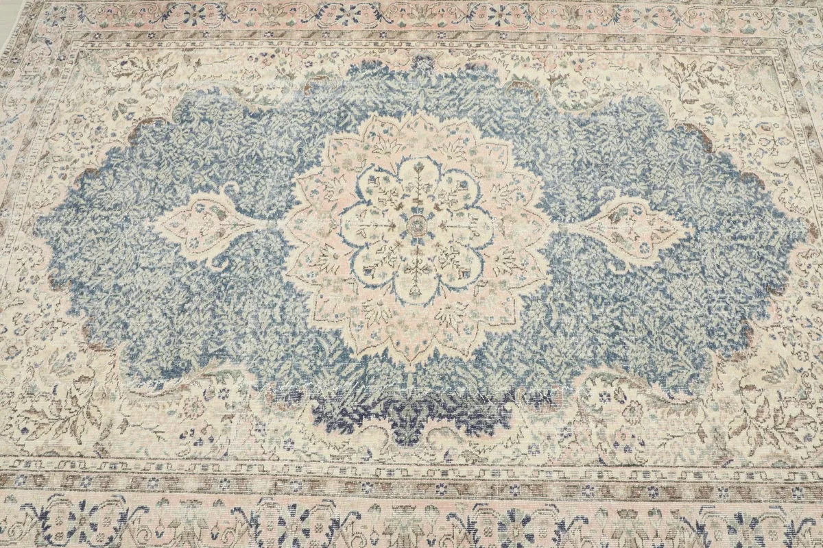 Detailed overhead shot of the rug's central design and border, revealing the hand-knotted texture.