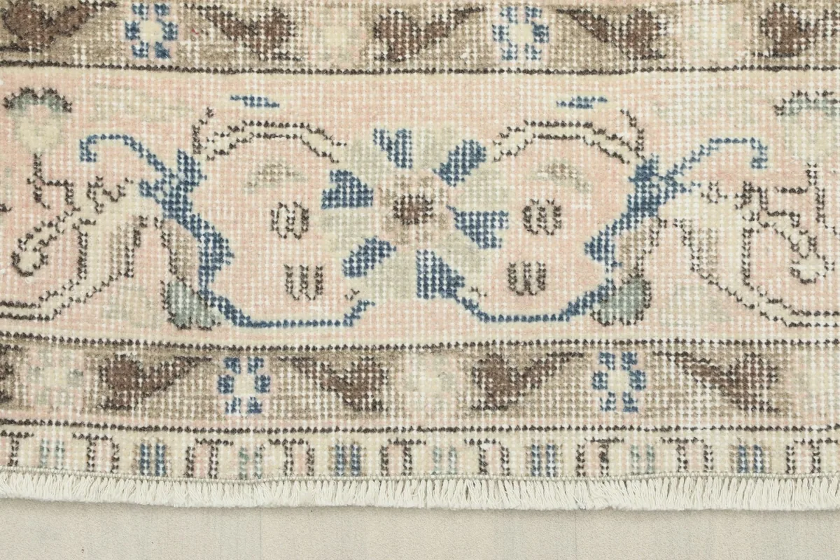 Close-up of the rug's border design, showcasing the intricate geometric motifs and color variations.