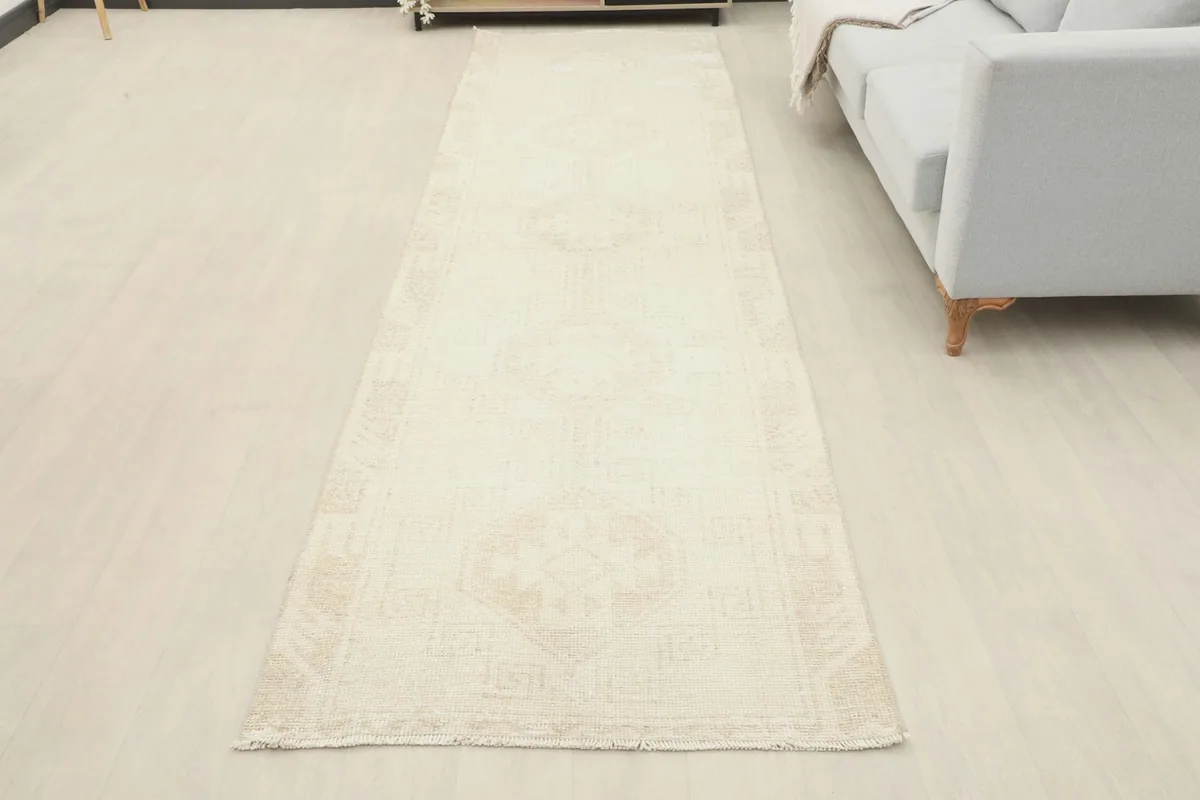 Full view of the ivory geometric runner rug laid out in a room, offering a perspective of its size and design.