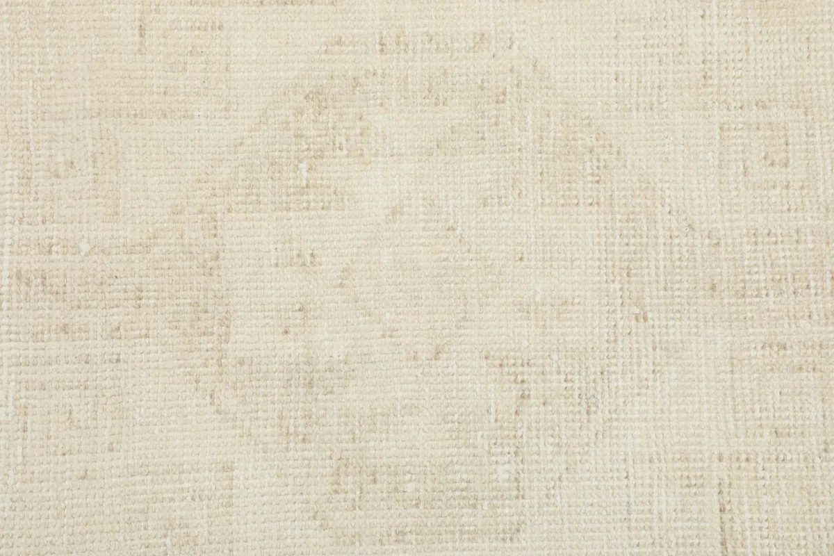 Detailed view of the rug's texture and a worn geometric medallion, emphasizing the vintage character and wool pile.