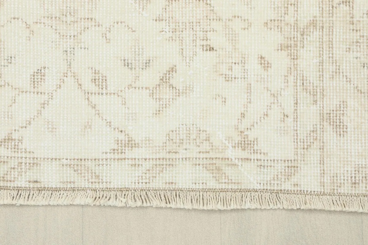 Close-up of the rug's edge, showing the subtle border pattern and the short fringe.