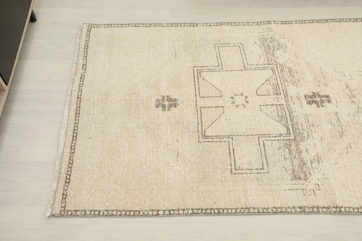 Overhead angle view capturing the central design and the border pattern of the vintage Anatolian runner.