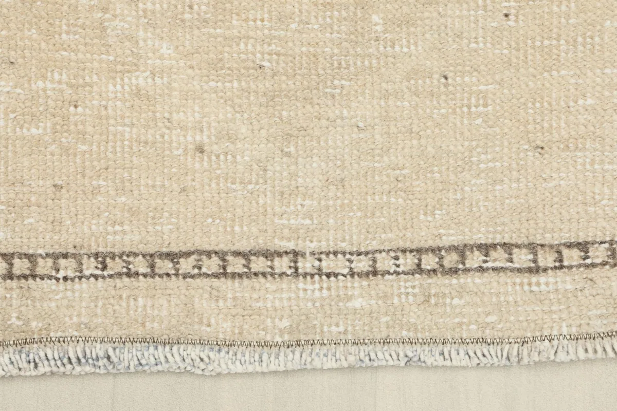 Close-up of the short, natural fringes and the finished edge of the hand-knotted wool runner.