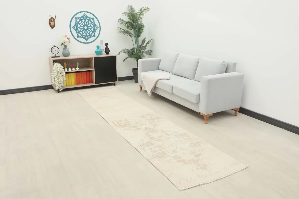 Vintage Anatolian runner rug displayed in a modern room setting, extending from a sofa towards the foreground.