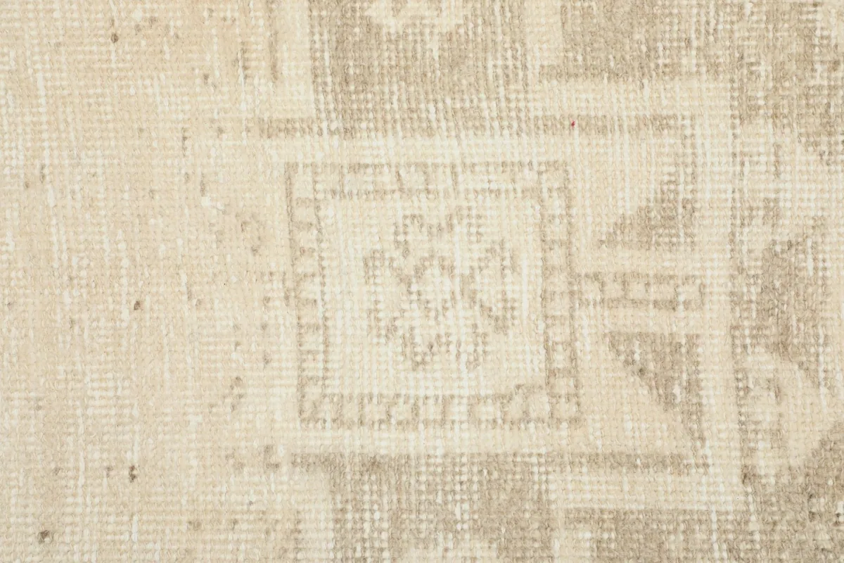Macro detail of a specific geometric motif within the rug, showcasing the hand-knotted wool texture.