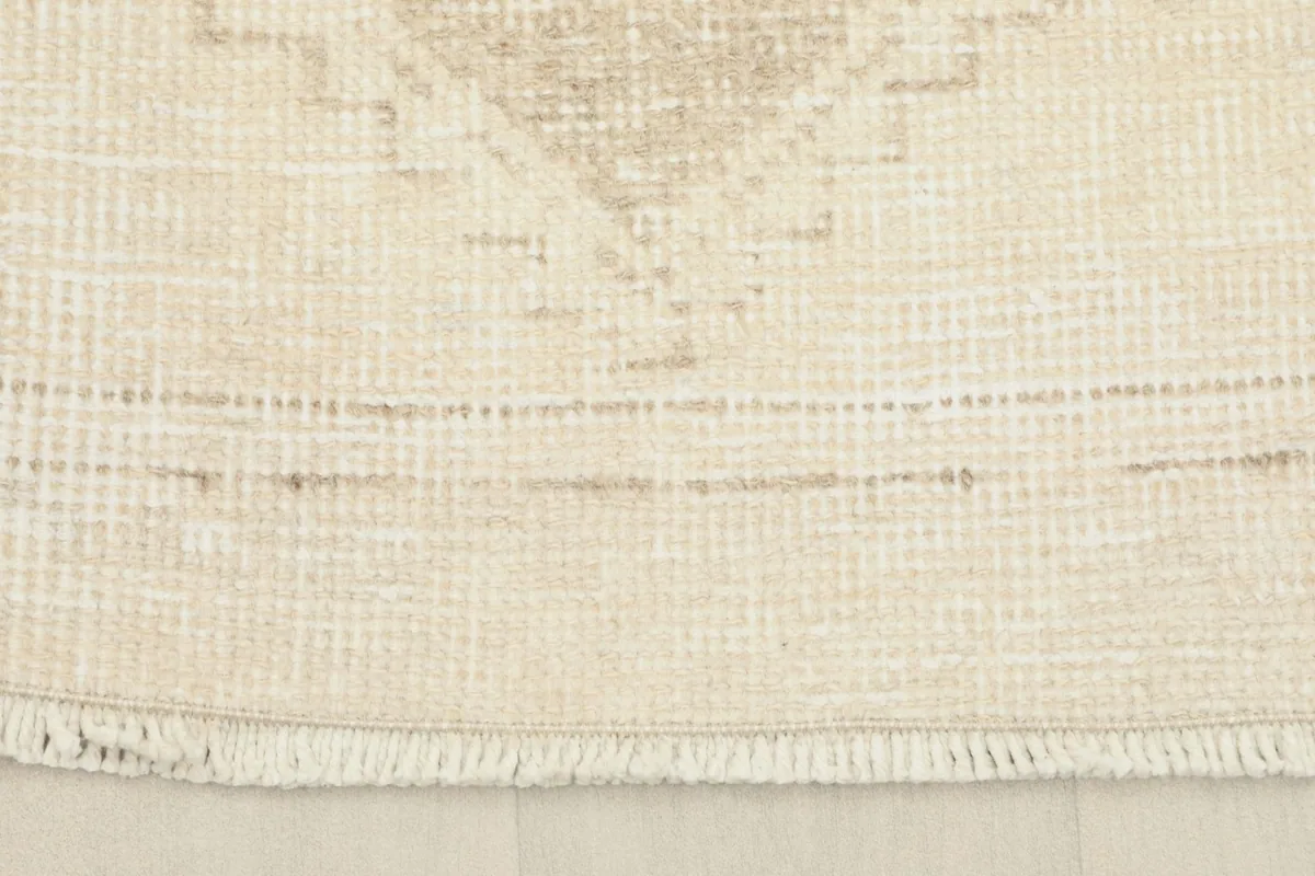 Detail of the rug's end, showing the short, natural fringe and the finished edge of the vintage runner.