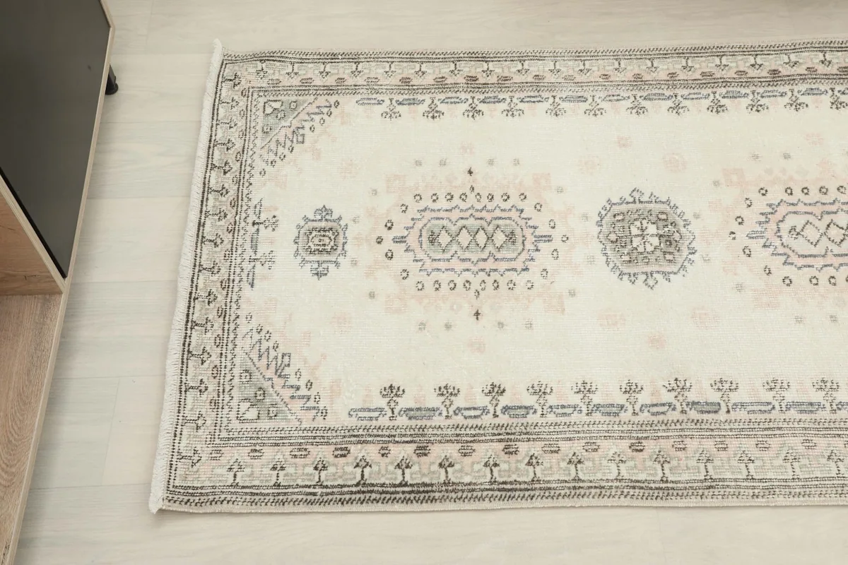 Detail of the runner's pattern and border, highlighting the subtle color variations and hand-knotted texture.